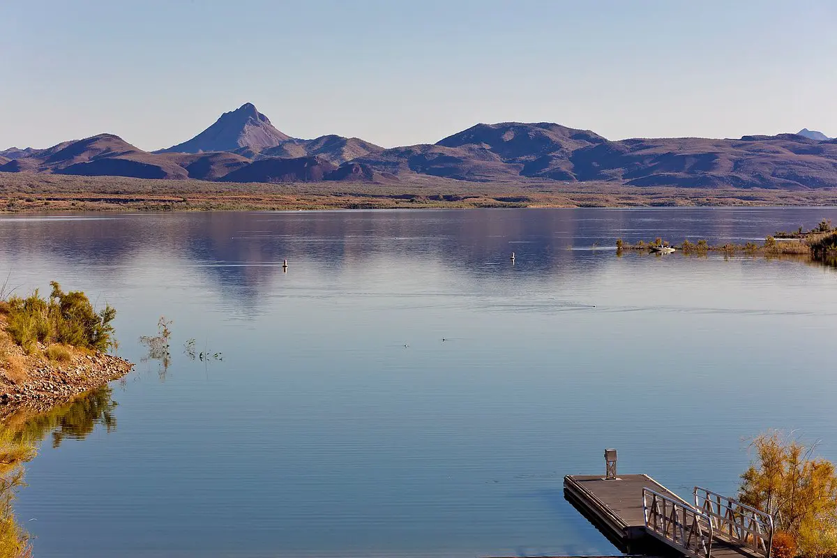 A dock on the water with mountains in the background.