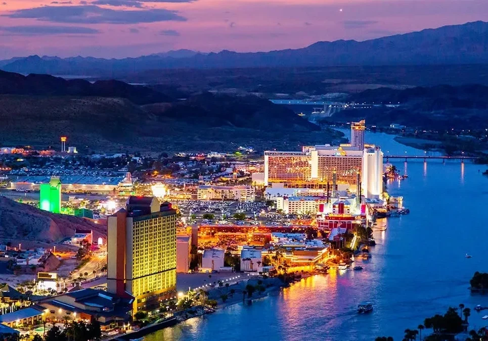 A city with lights and buildings on the water