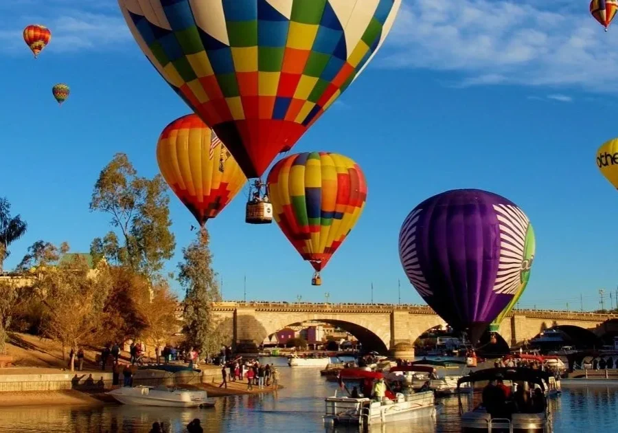 A group of hot air balloons flying over the water.